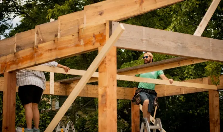 two people building a wooden structure