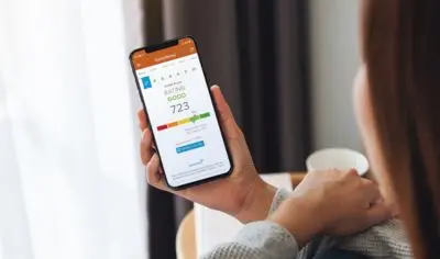 a person holding their phone showing their credit score