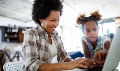 a woman and a child looking at a computer screen