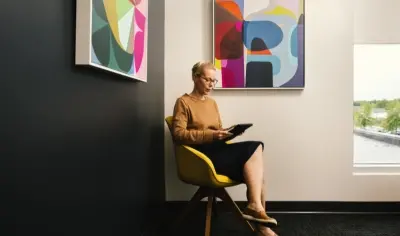 Person sitting in a chair using their tablet